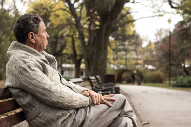 istock Senior man sitting on bench in the park 1223870892