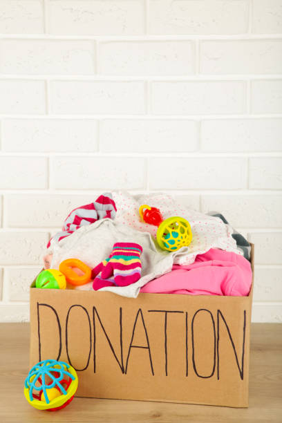 istock Donation box with baby clothes on light background 1223871183