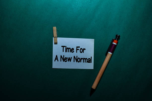 istock Time For A New Normal write on a sticky note isolated on Office Desk 1223875612