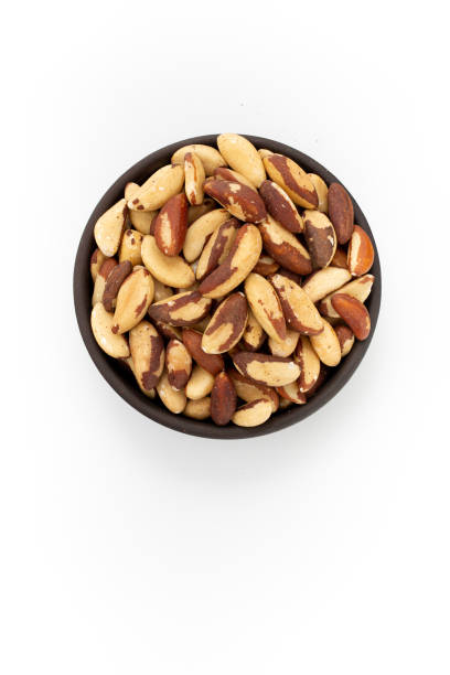 istock Brazil nuts in round bowl on white background, top view 1223877716