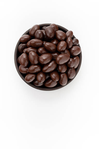 istock Chocolate Almonds nuts in round bowl on white background, top view 1223877736