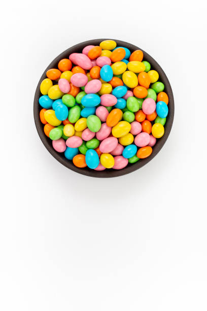 istock Peanuts in colourful sugar glaze in round bowl on white background, top view 1223877892