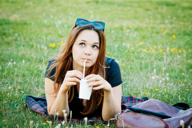 istock Pensive girl lies on the grass 1223877997
