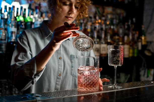 istock young woman's hand holds strainer over large glass with pink drink 1223879694