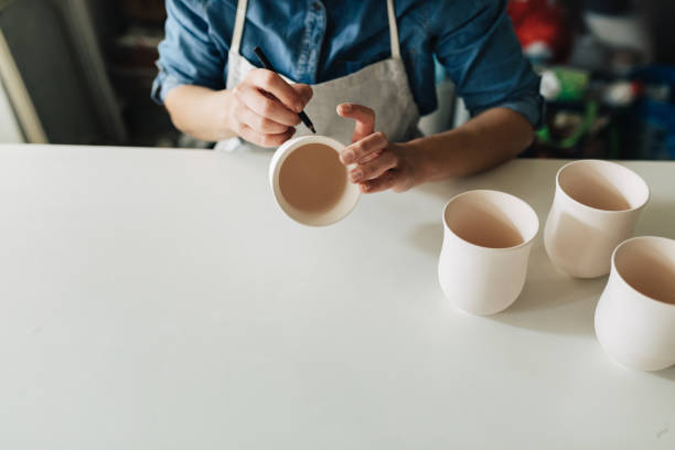 istock Woman Potter Drawing on Ceramic Cups 1223885057