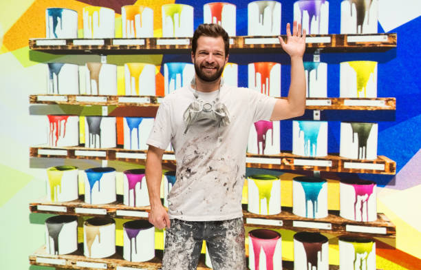 istock Caucasian male painter in the store and holding paint roller 1223885960