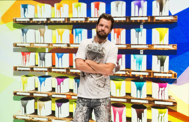 istock Caucasian male painter in the store and holding paint roller 1223886022