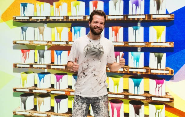 istock Caucasian male painter in the store and holding paint roller 1223886553