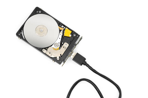 istock Disassambled Hard disk drive connected with a cable, isolated on white background. 1223887610