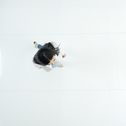 Aerial view of aged 20-29 years old who is beautiful with long hair latin american and hispanic ethnicity female business person walking in front of white background