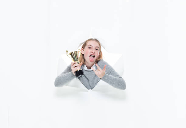 generation z young women student in front of white background wearing warm clothing and holding trophy - thank you excitement waist up horizontal imagens e fotografias de stock