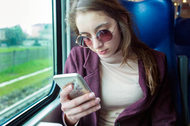 istock Young girl using smart phone in subway train 1223895743
