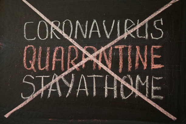 istock inscription stay at home. Outbreak Warning. written white chalk on blackboard in connection with epidemic of coronavirus worldwide. 1223895976
