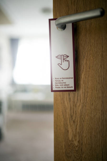 Open door with sign PLEASE DO NOT DISTURB on handle at hotel