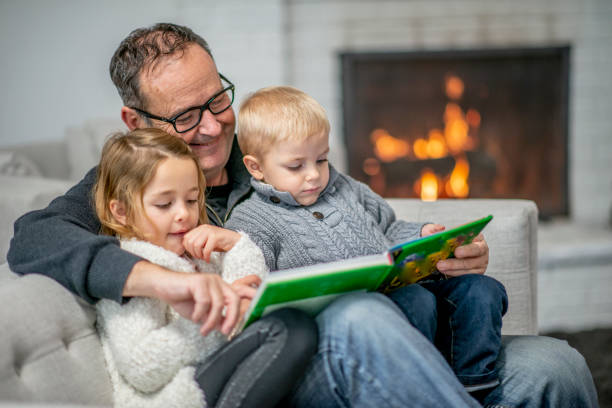 lecture de grand-père avec le petit-enfant - grandparent family reading inside of photos et images de collection