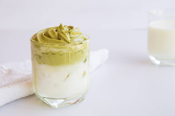 istock Home made Dalgona whipped green tea  in a cup on white table with a cup of milk background background. 1223902411