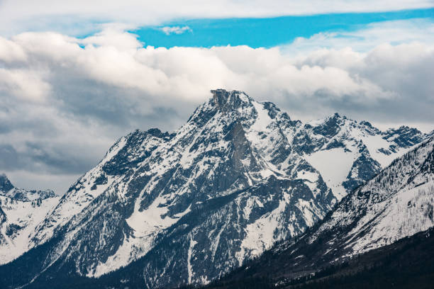 This is a photograph of the snow capped mountains seen on Jackson Lake in Grand Teton National Park in Wyoming, USA.