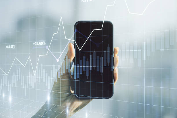 istock Abstract creative financial graph and hand with mobile phone on background, financial and trading concept. Multiexposure 1223903198