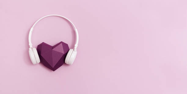3d фиолетовый бумаги сердце в белых наушниках. концепция музыкальных фестивалей, радиостанций, любителей музыки.  в прямом эфире с музыкой. м - pink and white radio стоковые фото и изображения
