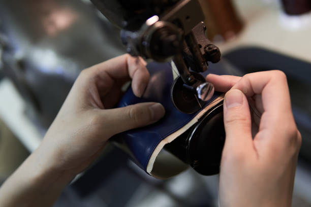 A woman's hand sewing leather with a sewing machine A woman's hand sewing leather with a sewing machine needlecraft product stock pictures, royalty-free photos & images