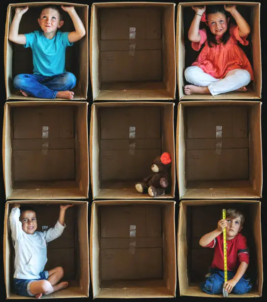 Photo of Feeling Isolated from Society Small Children Inside Enclosure Series Involving Cardboard Box Related to Shelter In Place During Illness Crisis