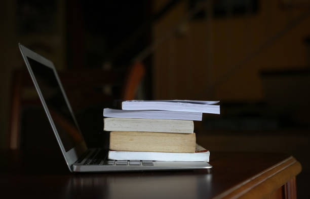 istock Books on top of computer laptop. 1223921940