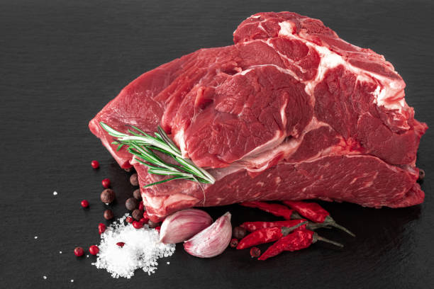 a piece of raw beef meat on a dark cutting board with spice - beef sirloin steak raw loin imagens e fotografias de stock