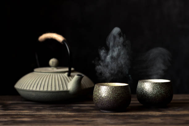 teapot and tea cups with steaming tea - tea cup cup old fashioned china imagens e fotografias de stock