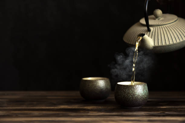 istock Teapot and tea cups with steaming tea 1223923712