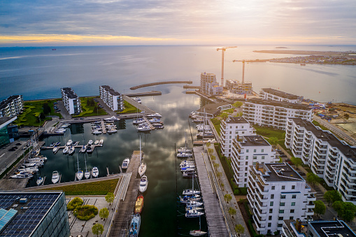 Aerial view of many white yachts and speed boats at harbor. Sailing boats moored at the port in a city pond near parking on a summer sunny day.