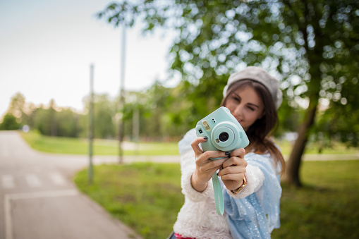 Young girl taking photos outdoors