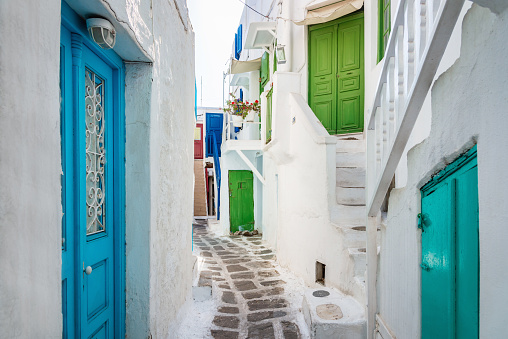 Mykonos Town Old Port Streets. Pedestrian walkway through the idyllic narrow streets with whitewashed traditional homes and buildings, colorful doors and window blinds. Mykonos Old Town, Mykonos, Cyclades Islands, Greece, Southern Europe, Europe.