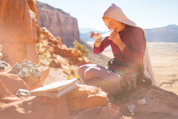 istock Woman reading a guidebook at a climbing crag in Utah 1223927812