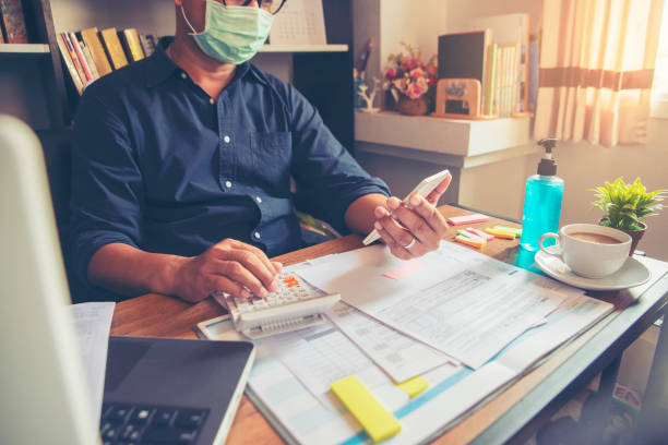 Budget planning concept Budget planning concept, Accountant wear mask is calculating the company's annual tax. Calendar 2019 and personal income tax forms for those who have income under US law placed on home desk. irs office stock pictures, royalty-free photos & images