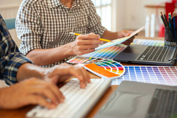 The design team is designing colors and working with laptops.