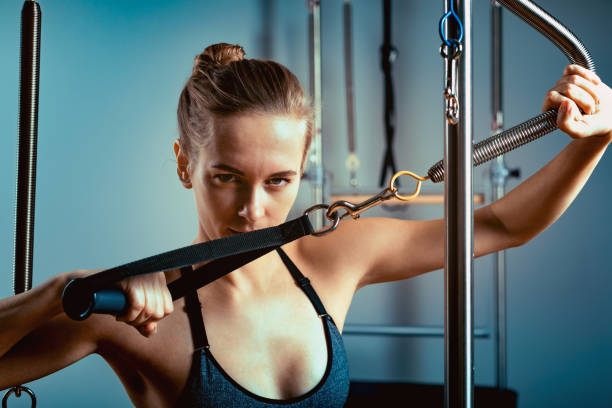 istock Pilates reformer bed, close-up, woman and instructor doing exercise on reformer simulator for treatment of musculoskeletal system 1223932126