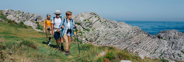 три человека, практикующих треккинг на открытом воздухе - nordic walking hiking mountain walking стоковые фото и изображения