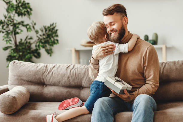 istock Little boy congratulating father with gift 1223936431