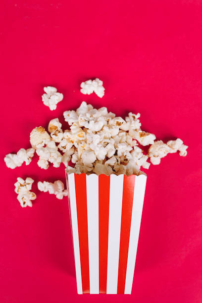 istock Popcorn in cardboard box on red background 1223937534