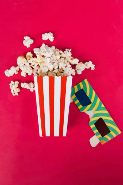 Popcorn in cardboard box on red background
Conceptual cinema, watch a movie