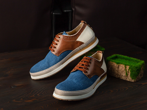 Pair of stylish sneakers on a dark wooden background. Casual and sport shoes. Side view, close up