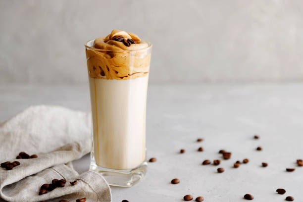 istock Trendy cold, summer dalgon drink on milk with coffee foam on a gray background with a linen beige napkin next to it. Save the space. Horizontal orientation 1223940233