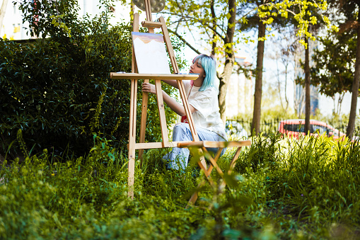 Young Beautiful woman painting a picture on canvas