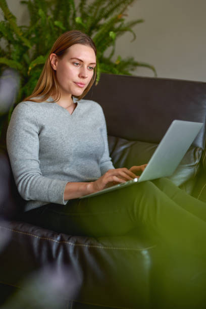 istock beautiful woman using a laptop computer at home 1223942863