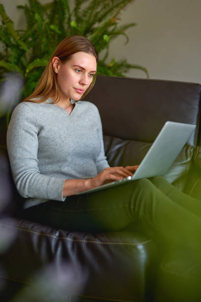 istock beautiful woman using a laptop computer at home 1223942864