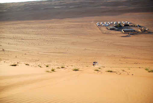 Sossusvlei, Namibia - October 6, 2021:  Four off-road vehicles parked in front of the sand dunes in Sossusvlei, Namibia. This is the parking lot at Dune 45, one of the largest dunes in the world and therefore visited by many tourists.