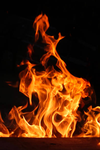 image of roaring , dancing flames from beach barbecue burning wood against night sky, outdoor beach restaurant - bonfire beach fire barbecue imagens e fotografias de stock