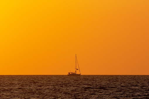 The sun sets over a nautical vessel in the Aegean Sea