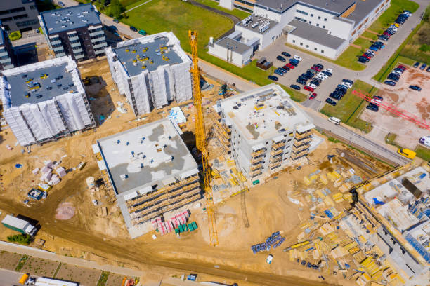 istock Construction site with cranes. Construction workers are building. Aerial view of construction site of residential area buildings with cranes 1223945706