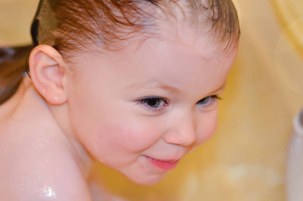 cute little girl washing herself in the bathtub